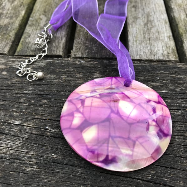 Purple patterned shell on purple ribbon