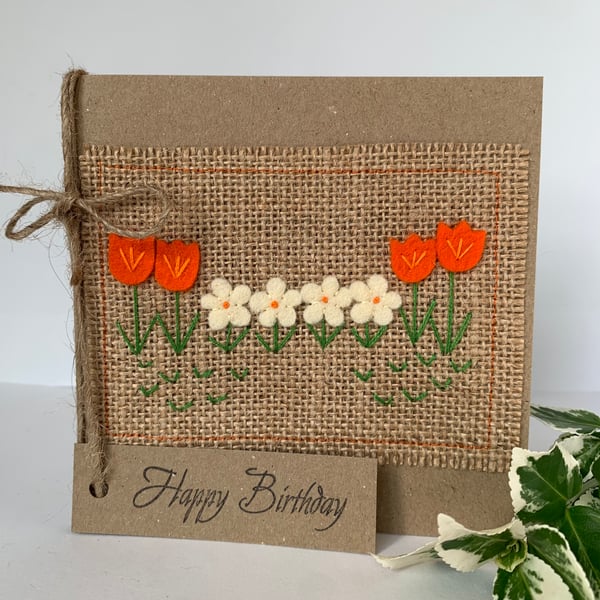 Handmade birthday card. Row of bright orange and cream flowers from wool felt.