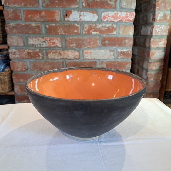A HAND MADE CERAMIC BOWL -  with burnt orange and charcoal glazes