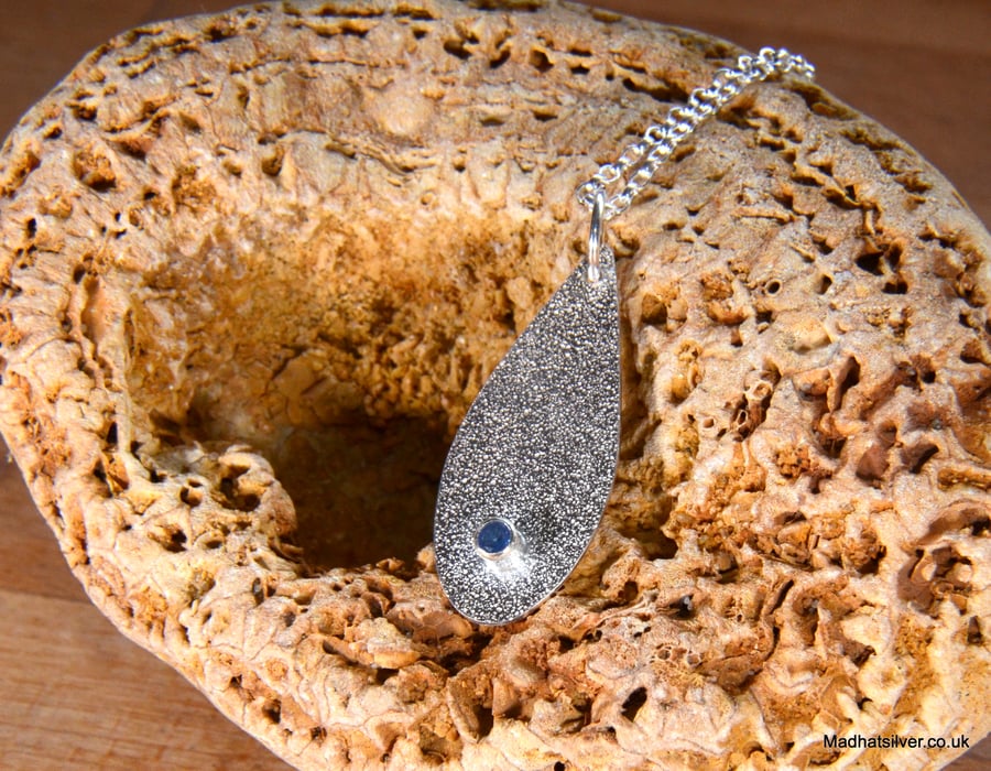 Textured silver teardrop pendant with topaz stone