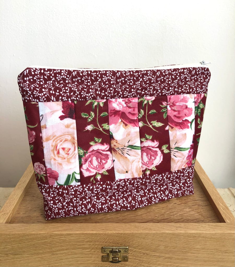 Toiletry bag in damson & white floral panelled design.