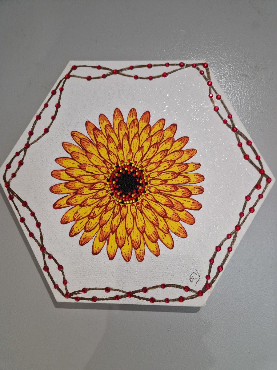 A hand crafted collage of a flower on canvas. 