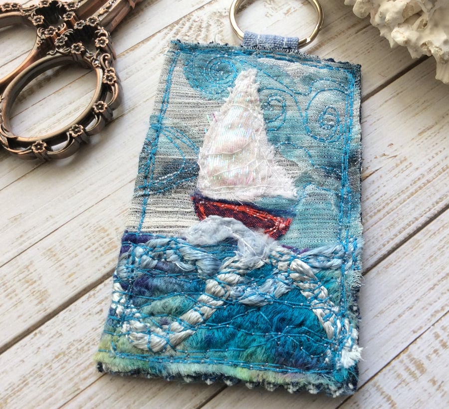 Up cycled seascape keyring with sail boat. 