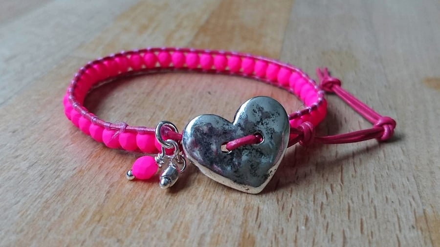 Neon pink glass bead and leather bracelet with heart button