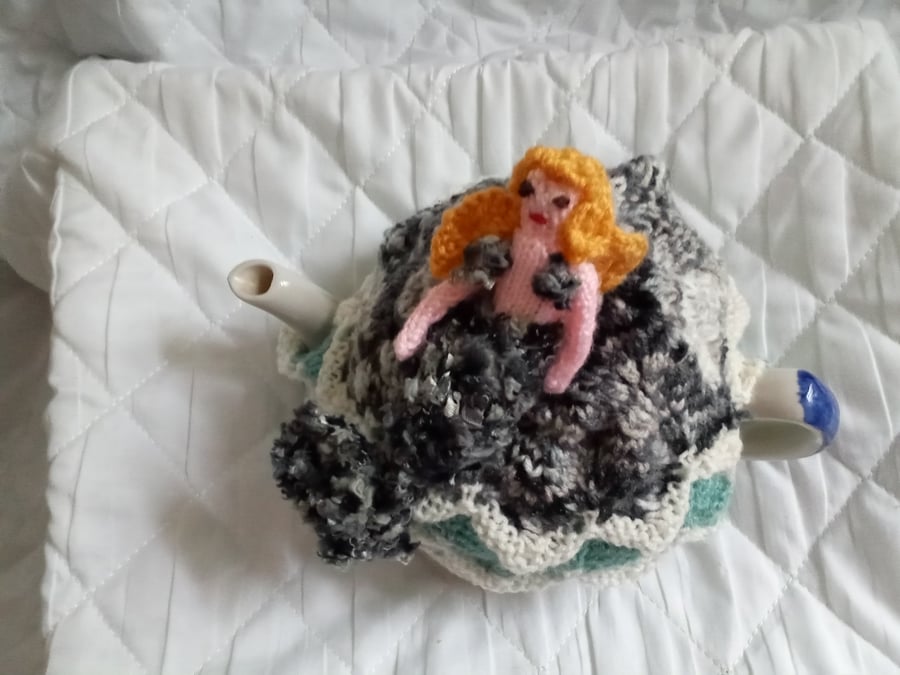 A mermaid on a rock tea cosy