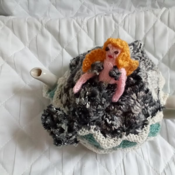 A mermaid on a rock tea cosy