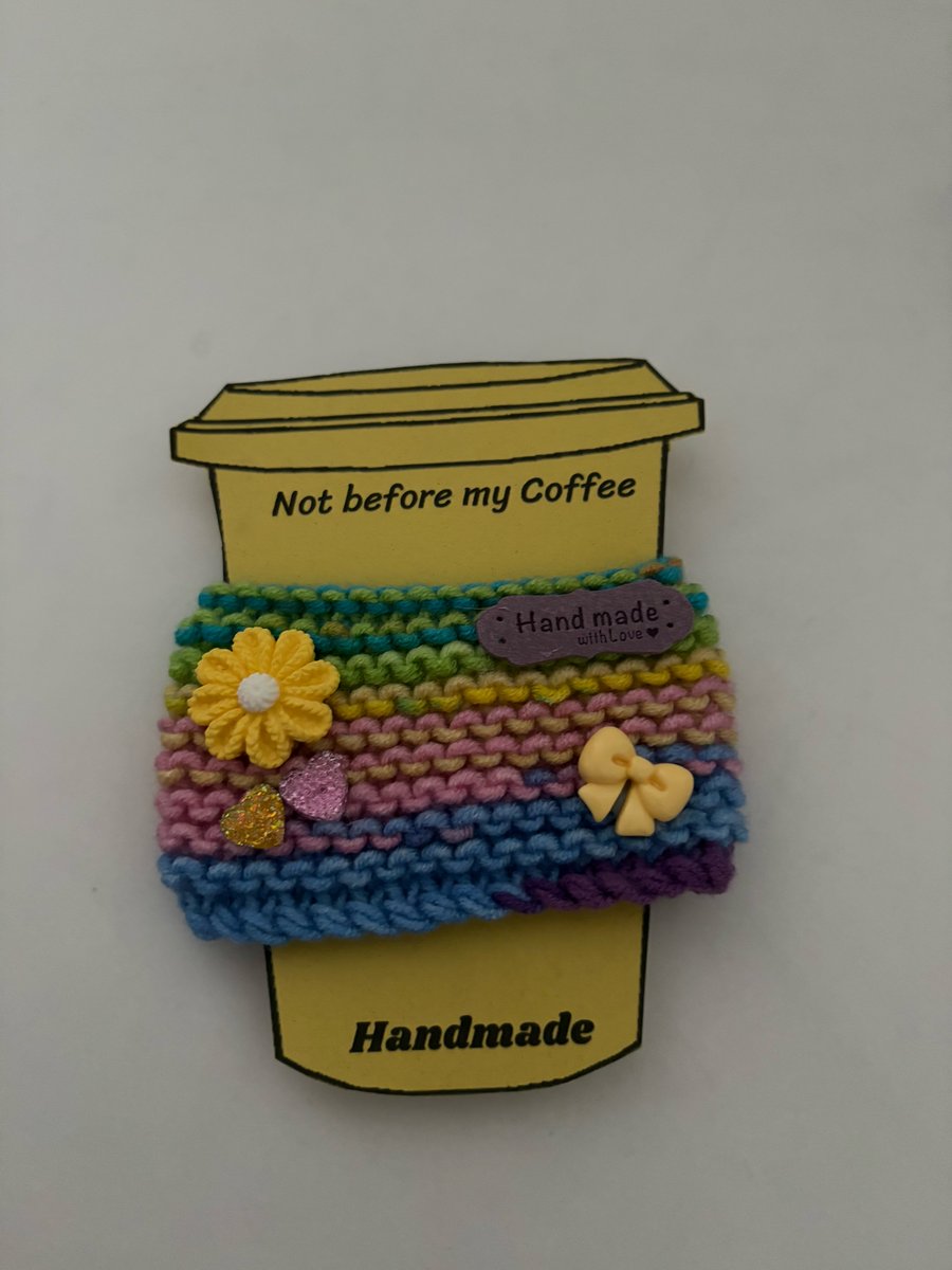 Flower and bow knitted cup cosy. 