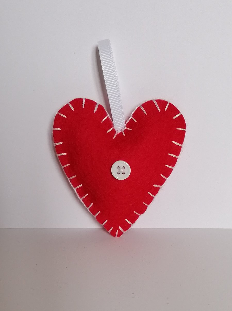 Handmade red felt heart with white stitching, ribbon and button 
