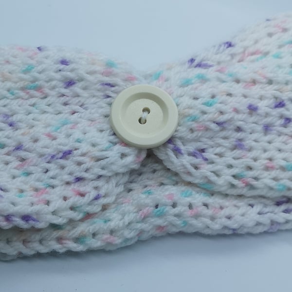 Handknitted white earwarmer with flecks of pink, purple and blue