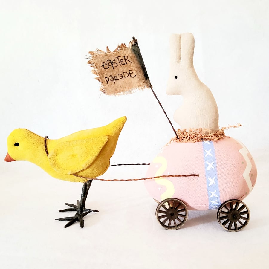 Primitive easter egg and bunny pulled by a bird on wheels