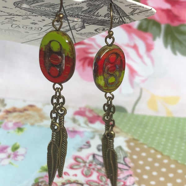 Feather charm earrings with red and green glass beads