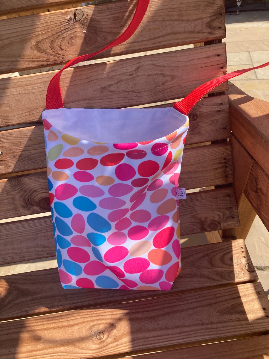 Peg bag with red shoulder strap. Multi-coloured spotty showerproof fabric.