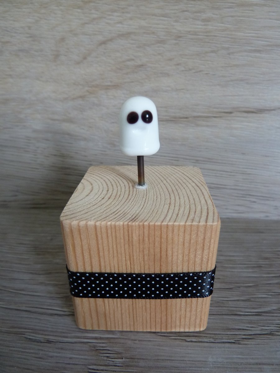 glass halloween ghost on wooden block