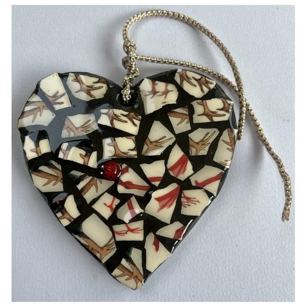 A heart shaped mosaic pendant with a sylised brown and red birds' feet theme.