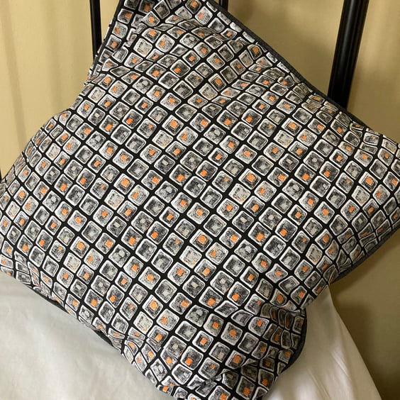 A pair of grey black and orange combo piped cushion covers. Zipped on one side.
