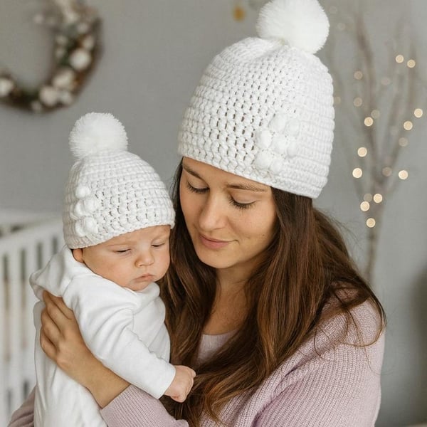 Matching ladies and baby white crocheted hats with detachable faux fur pompoms