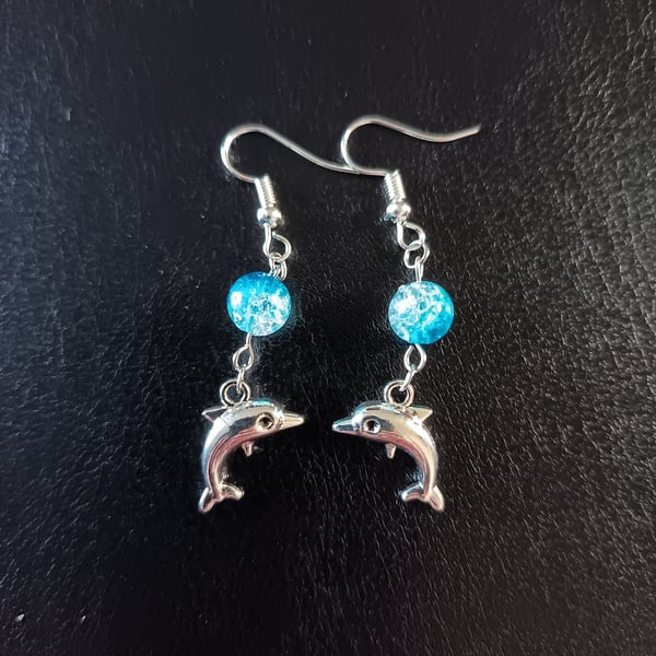 Silver dolphin charm dangle earrings with blue bead detail