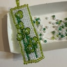 Beaded pendant with raised flowers 