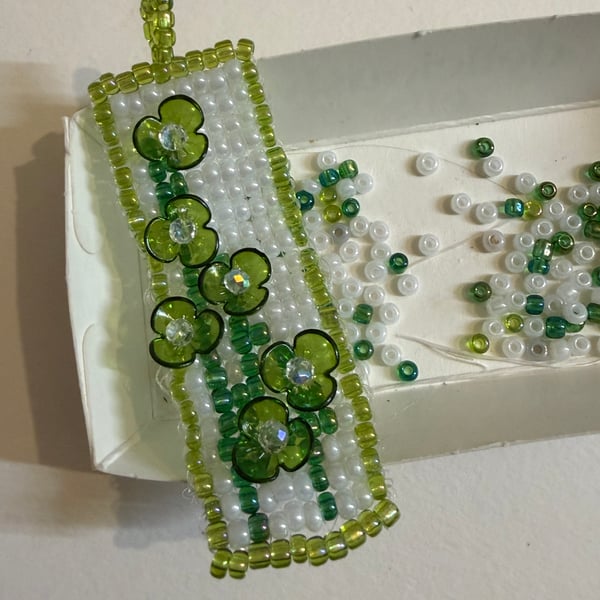 Beaded pendant with raised flowers 