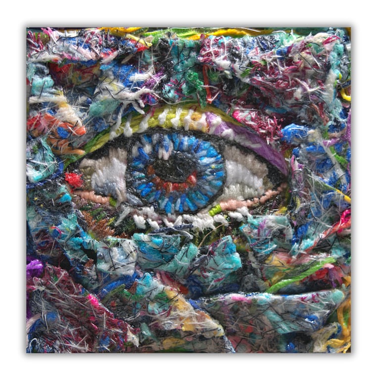A small framed fibre artwork - needlework - eye - threads - hand stitched