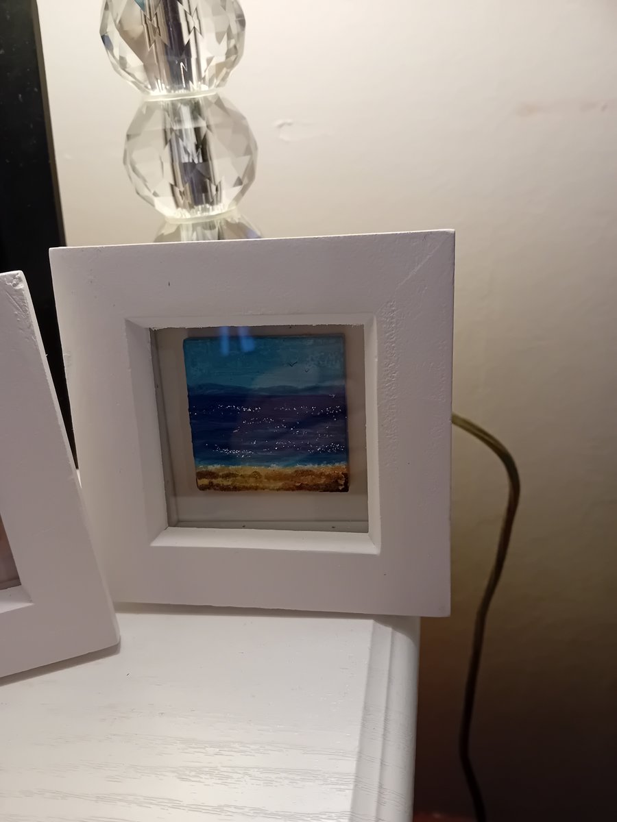  Handpainted shimmering seascape and golden sand, in white wooden box frame.