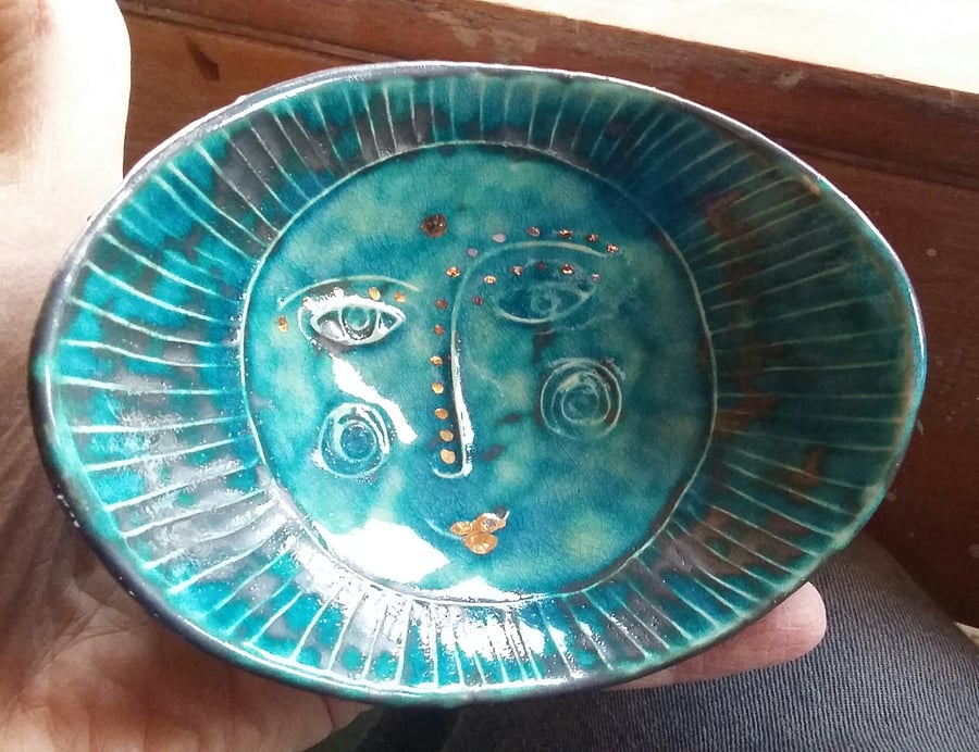 Hand size bowl .With raised sun face motif. 