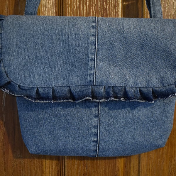 Repurposed blue denim handbag, shoulder or hand held strap length. Décor frill.