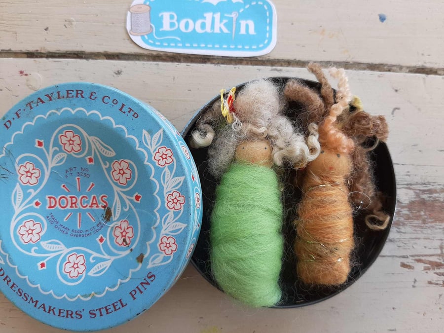 Two baby bodkin brooches in vintage tin