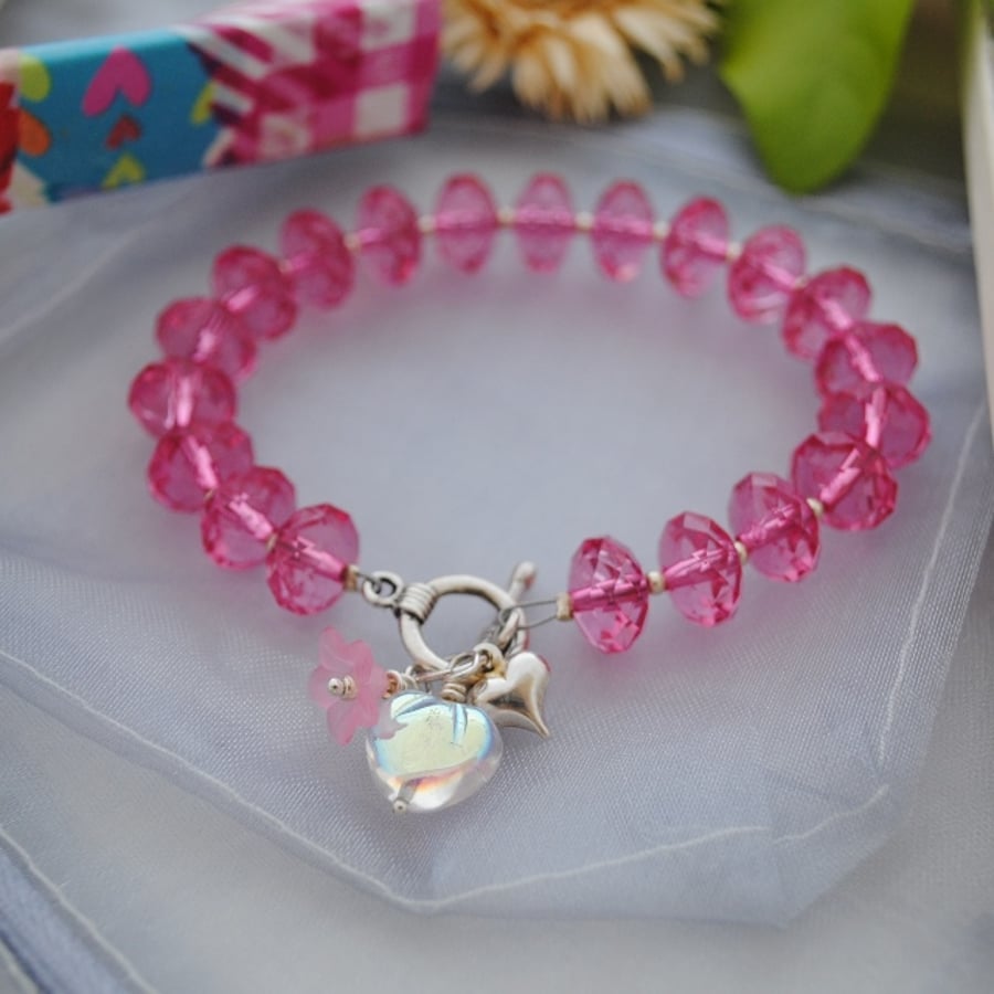 Child-pink rondelle bracelet with heart & flower charm