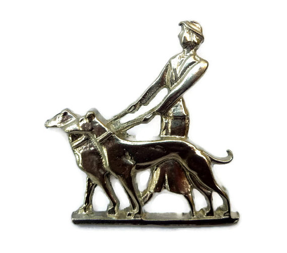 Art deco brooch, lady and dogs.