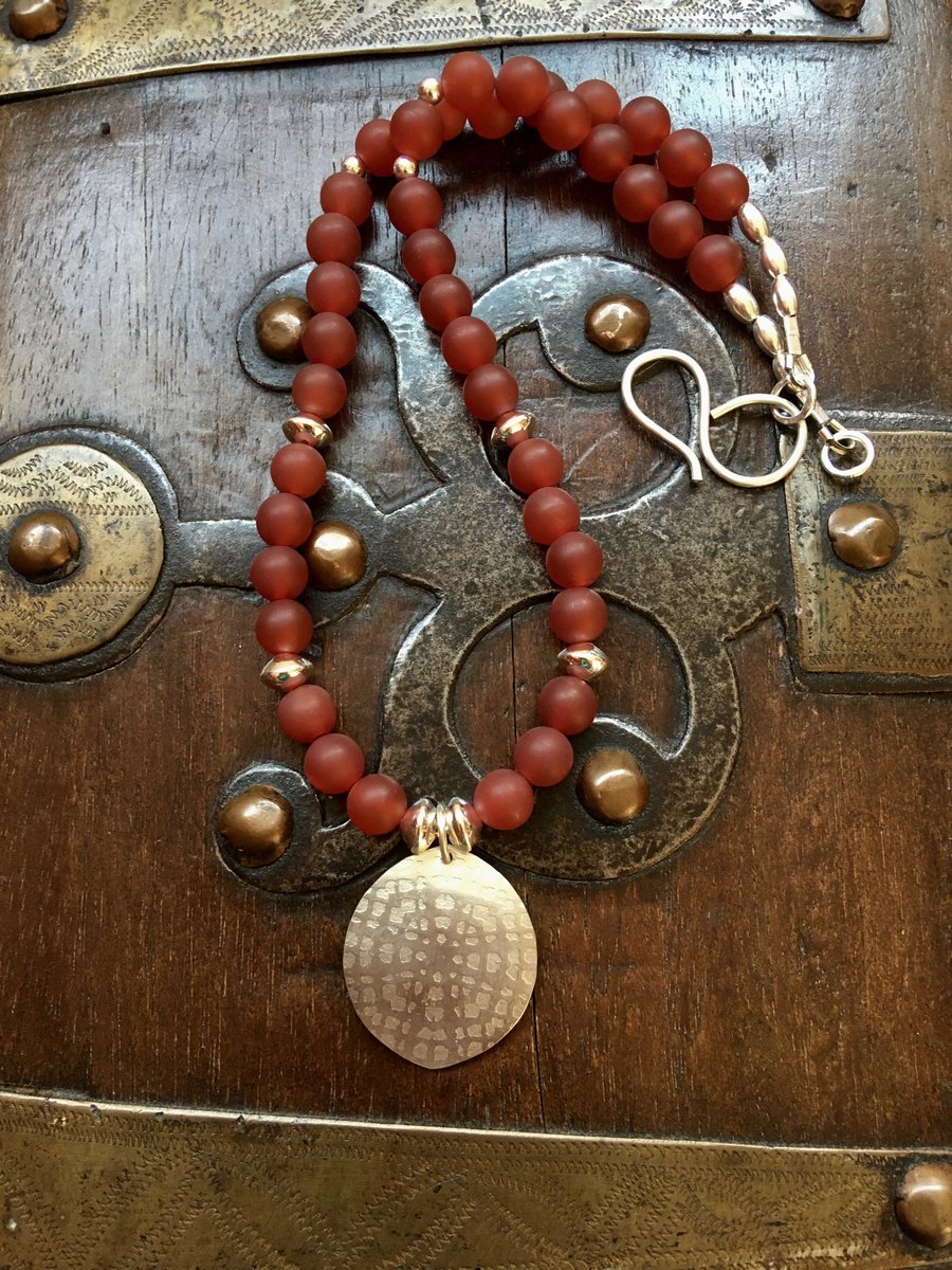 Textured hand-cut silver pendant, matte red orange carnelian beads