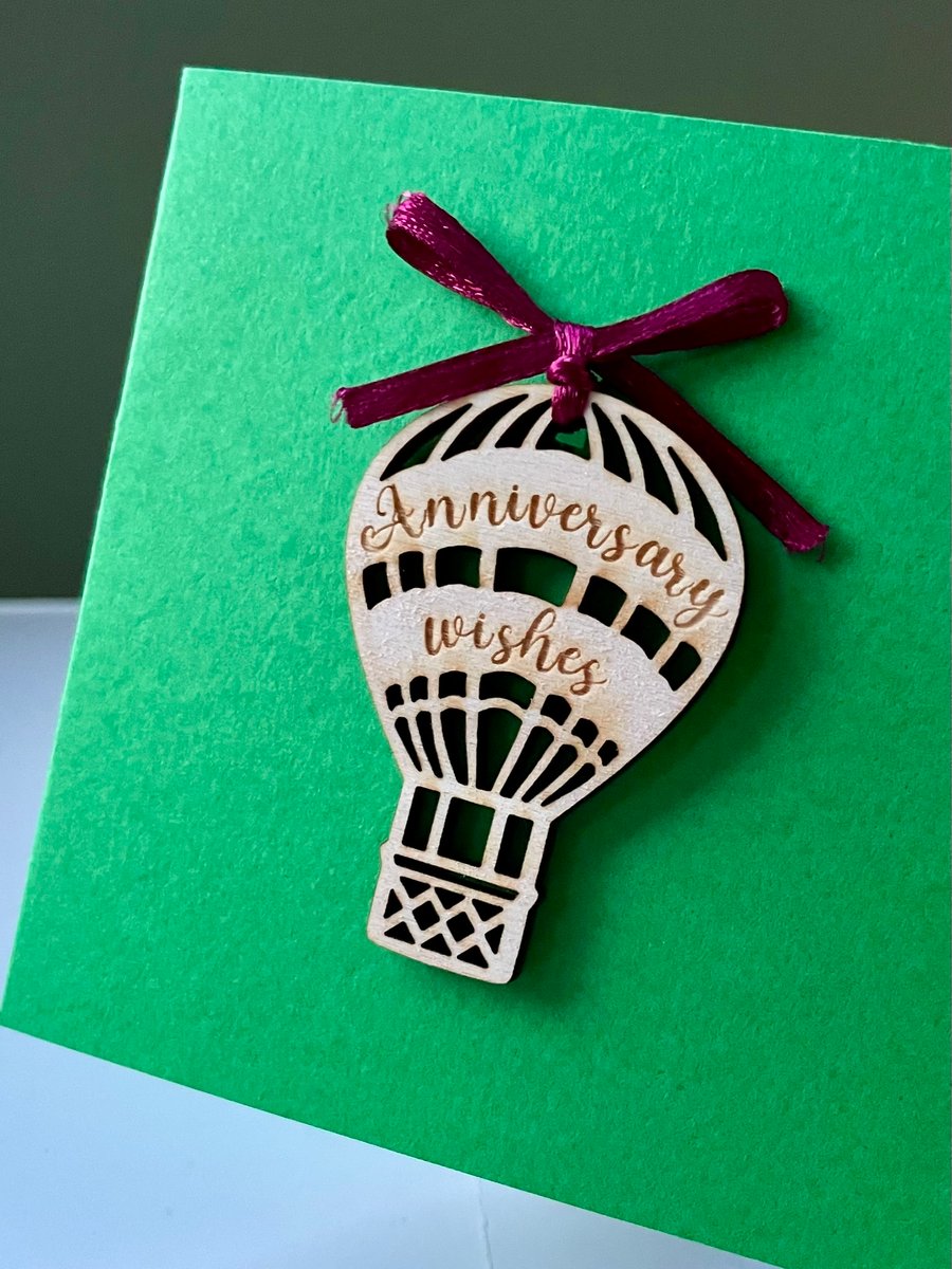 Blank card with detachable wooden 'Anniversary wishes' balloon decoration