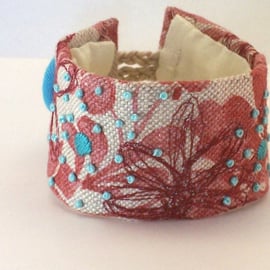 Hand stitched linen cuff in rust with turquoise embroidery