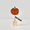 A Glittery Pumpkin with a Wire Stem & Wooden Block Stand
