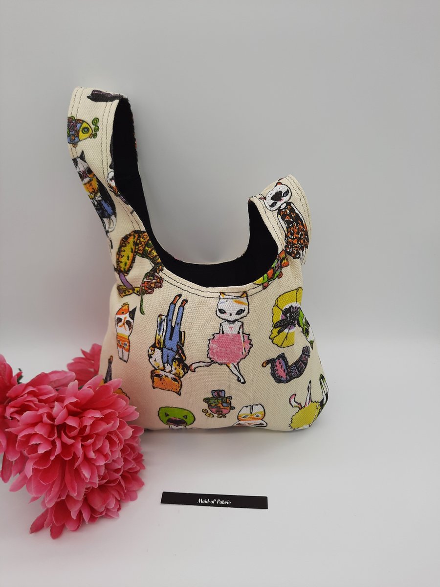 Japanese knot bag,  small, reversible in black mole skin and crazy cats. 