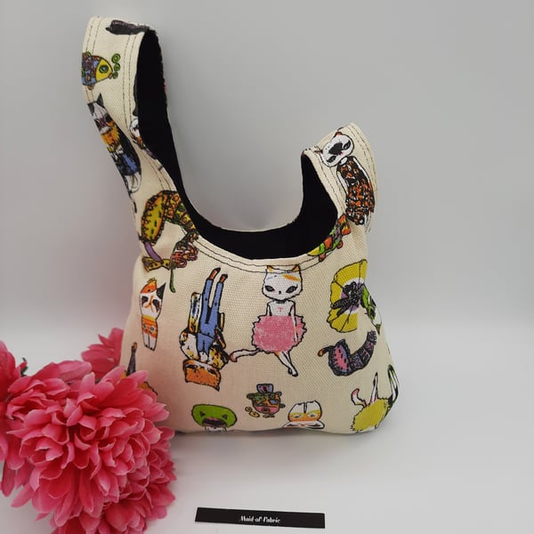 Japanese knot bag,  small, reversible in black mole skin and crazy cats. 