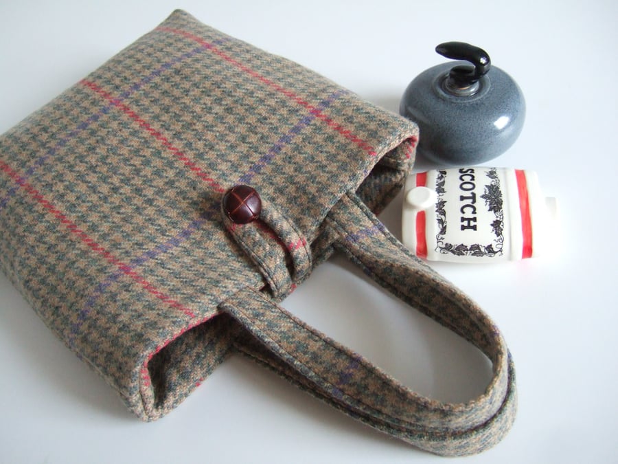 A little woollen bucket bag made from brown and green checked wool.