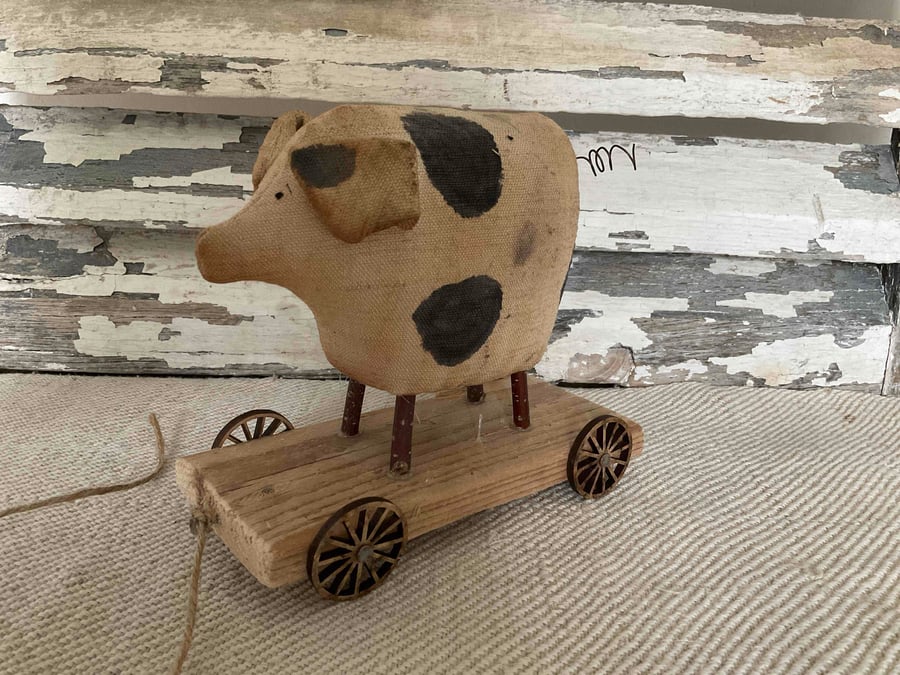 A lovely primitive handmade pig on wheels