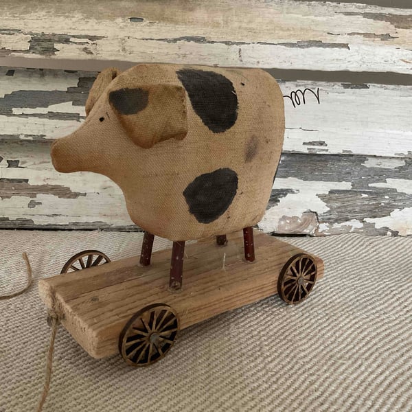 A lovely primitive handmade pig on wheels