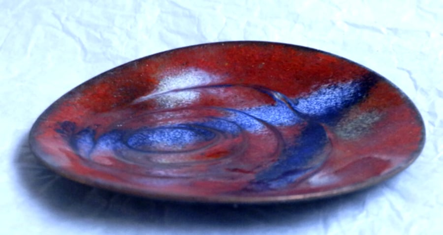 red dish decorated with scrolled blue and white pattern