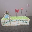Fairies Welcome printed on a wooden block with Blue ceramic fairy