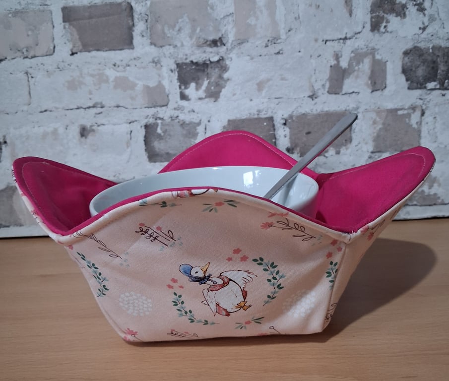 REVERSABLE BOWL COSY IN PUDDLEDUCK AND PINK FABRIC.