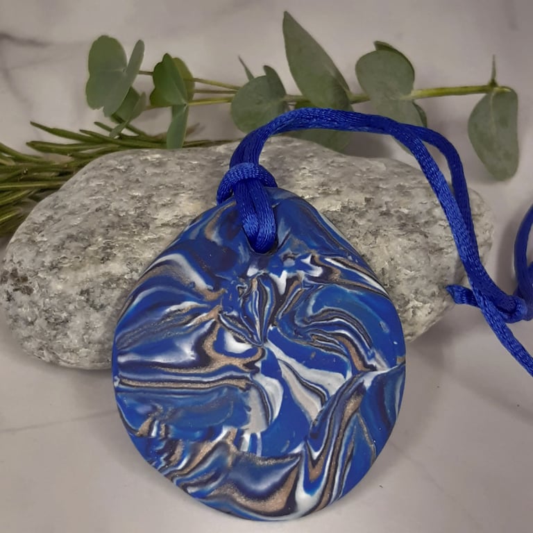 Round polymer clay pendant in bright blue, white and sienna