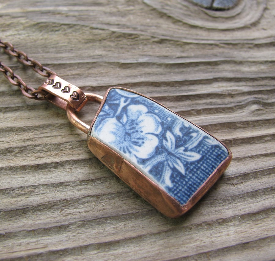 Worn pottery pendant set in aged copper bezel