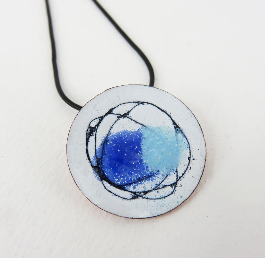 Round enamel and copper pendant with a hand drawn lines and colour.