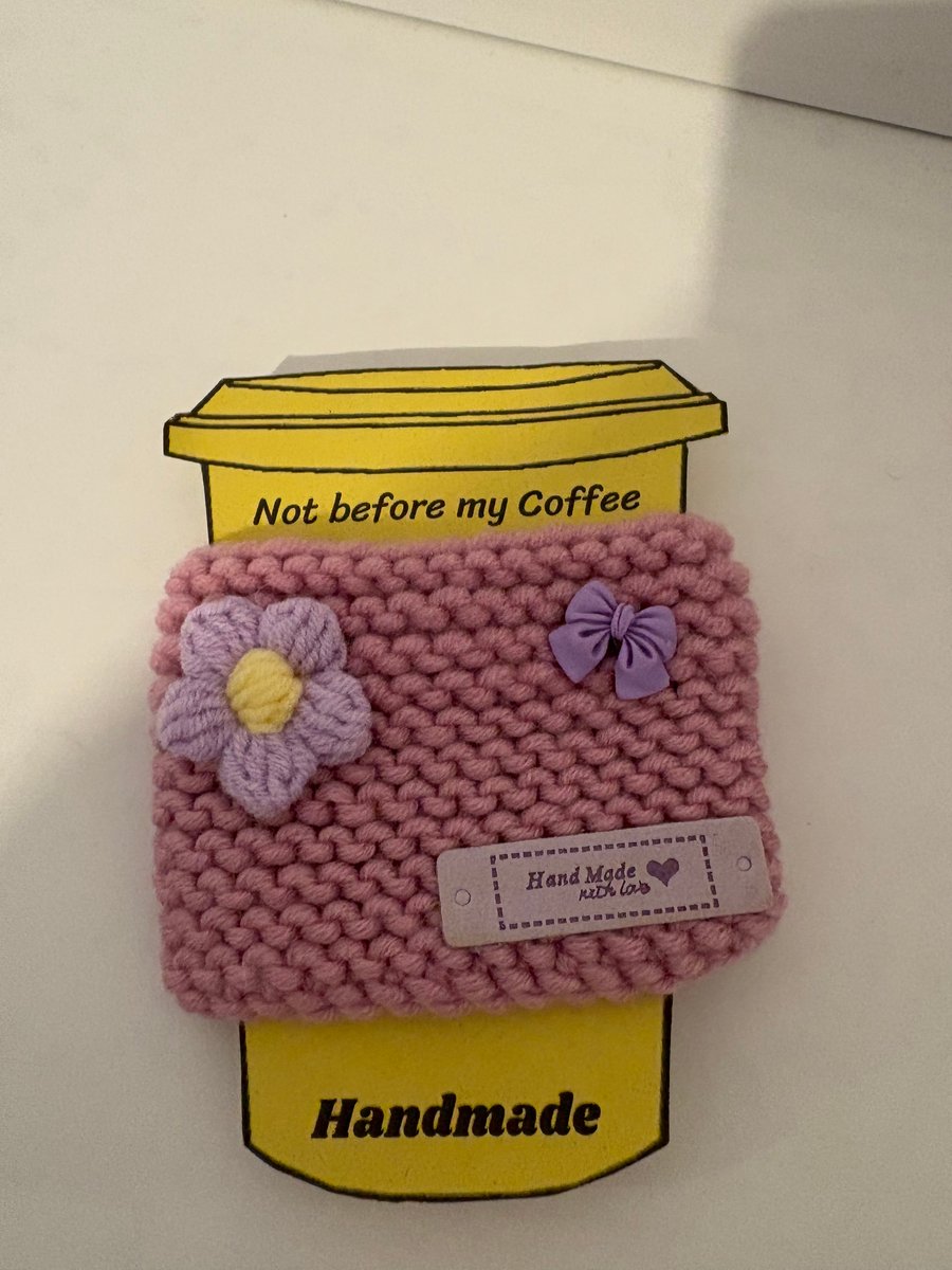 Pink flower and bow knitted cup cosy. 