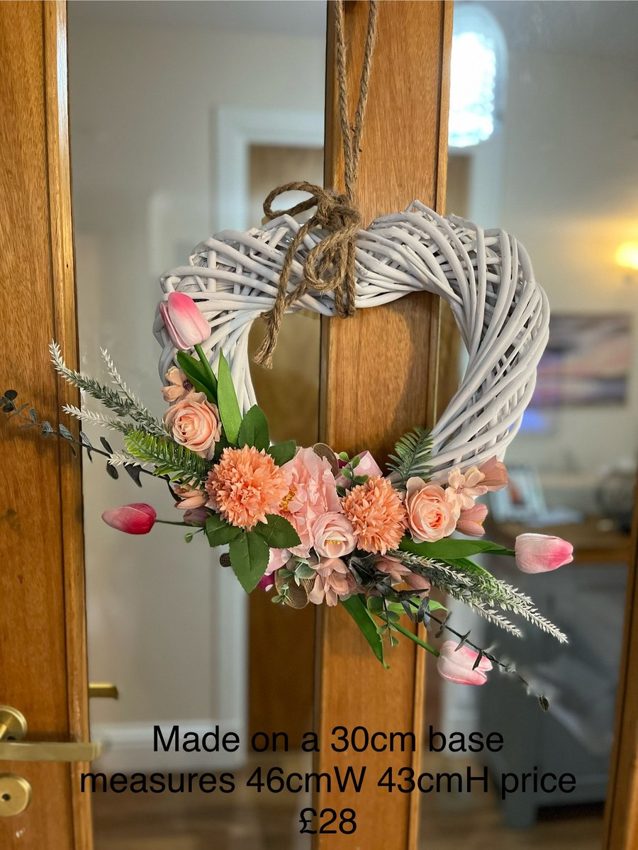 Peach and pink flowers on white wicker heart wreath 