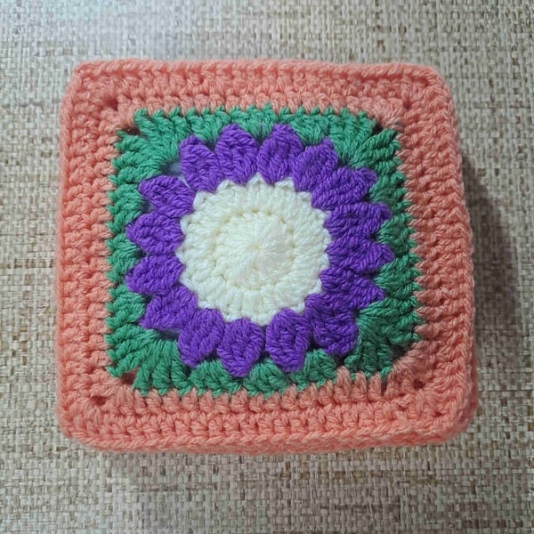 Purple flower with peach boarder crochet block