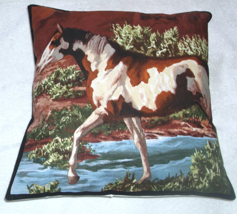 A beautiful brown  and white horse stepping through a stream cushion