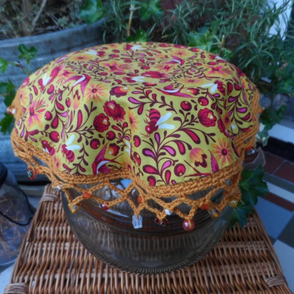 Insect Jug Cover in a deep pink and mustard bee and floral print fabric. 